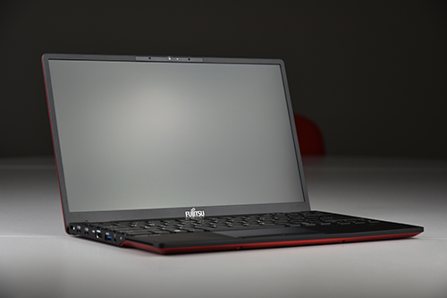 Laptop Fujitsu z czarną obudową i czerwoną krawędzią, ujęcie z boku pod kątem